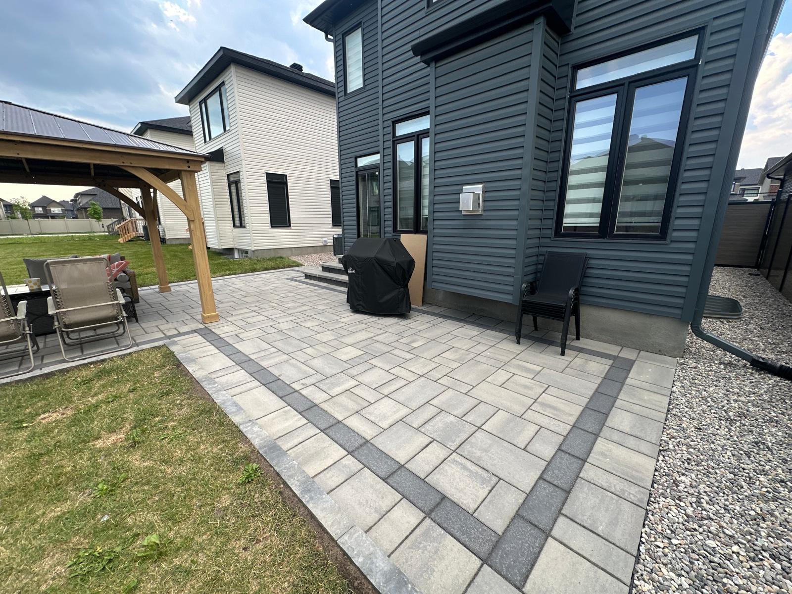Luxury interlock stone driveway installation in Ottawa with modern paver design, clean edges, and high-end residential landscaping for homeowners